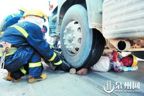 救援人员设法抬高车轮，解救被压的男子。